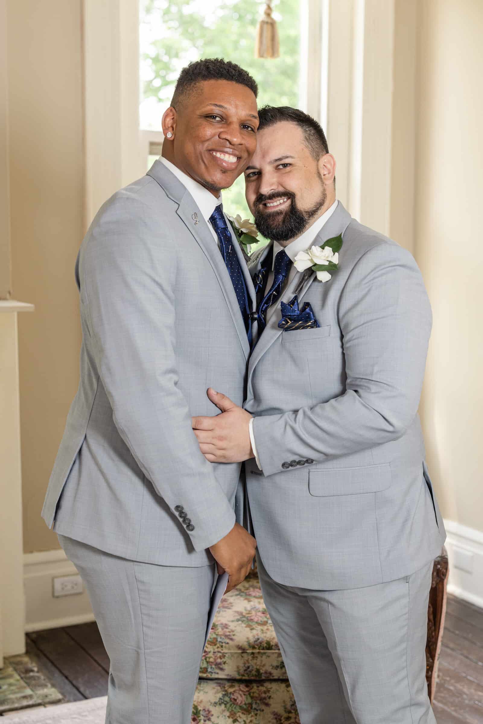 Same-sex male couple pose together inside antebellum mansion